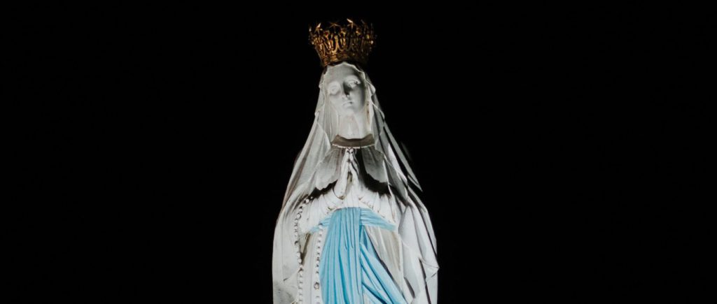 virgin mary statue on black surface