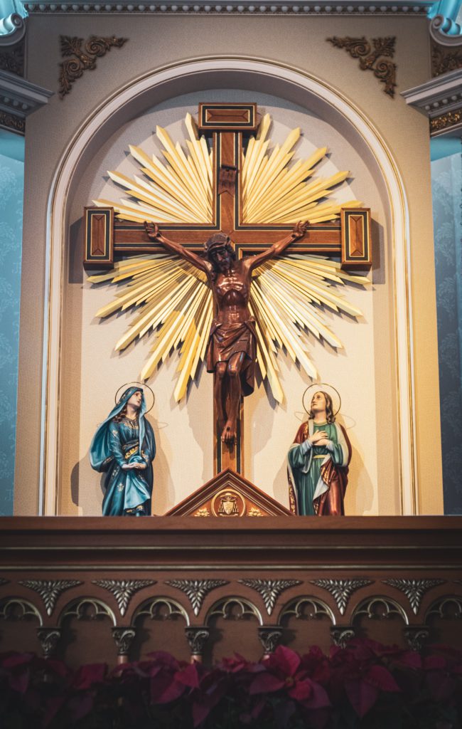 crucifix beside religious statues inside building