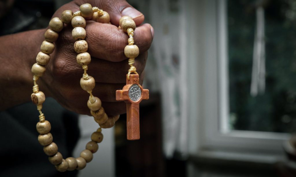 brown beaded necklace on persons hand