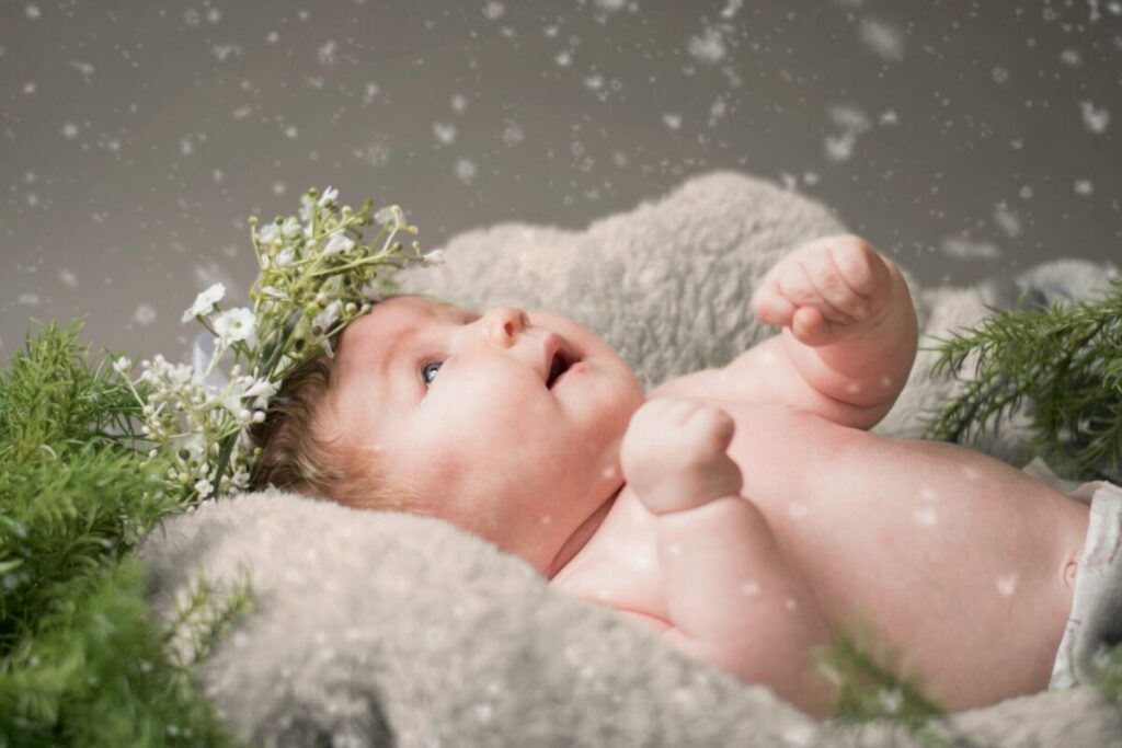 baby lying on gray textile