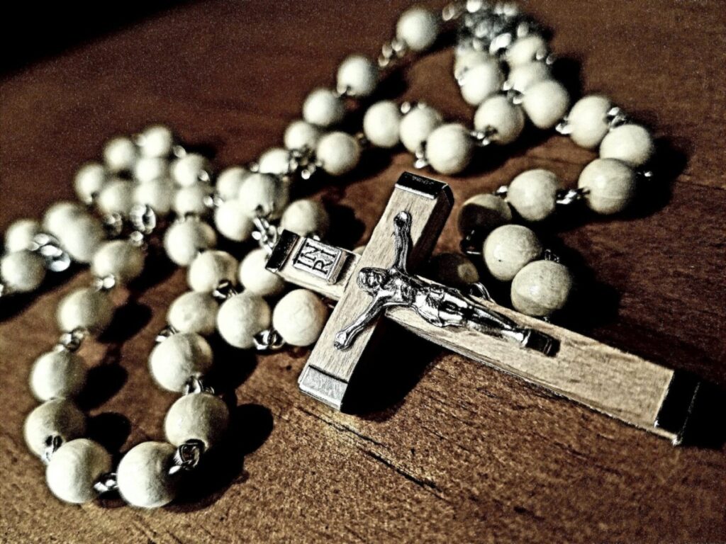 Faith in the Rosary: Background of rosary made of olive wood resting on top of wooden surface.