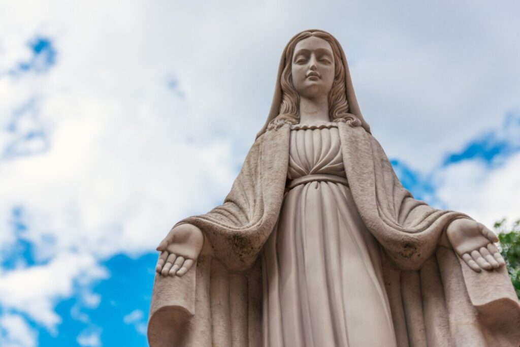 Marble figure of the Virgin Mary. Blue sky background.