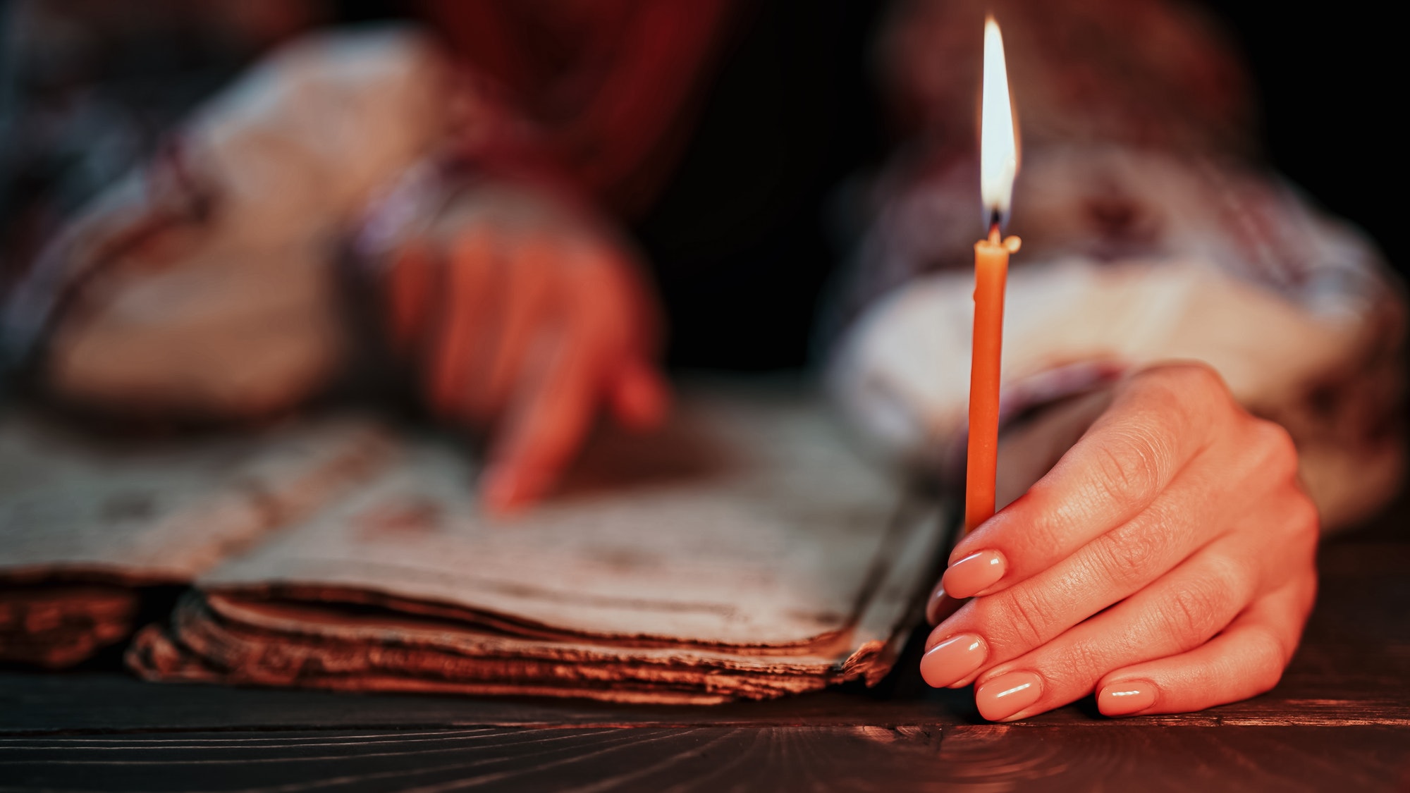 Ukrainian woman reading ancient book - Bible. Concentrated attentively follows finger on paper page